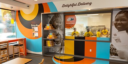 A striped wall wrap and floor graphic make a commercial kitchen welcoming.
