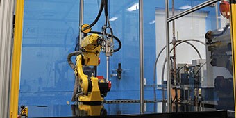 Image of a robot used to apply adhesive in a precise pattern
